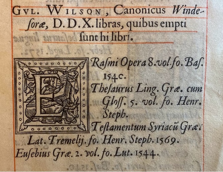 Image of William Wilson's entry in the register. This includes his name, titles, and books given in Latin. The text is printed in black ink and is surrounded by a red border. It also features a woodcut initial E depicting a figure writing into a book.