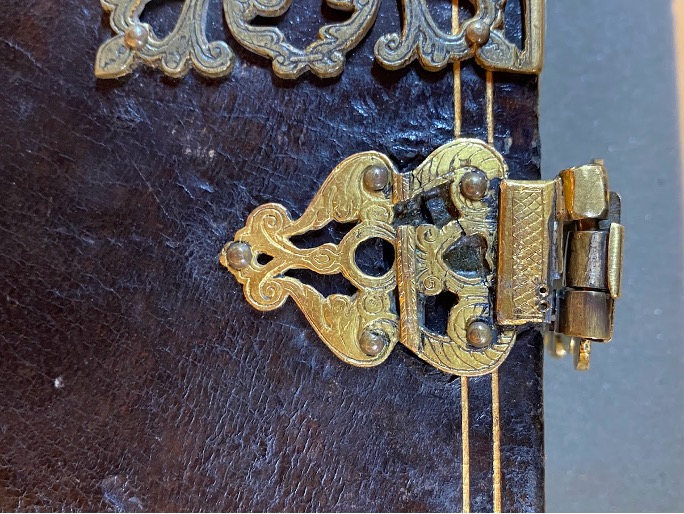 Image of one of the register's gilded clasps. A piece of metal has been soldered to the terminal to repair a break.